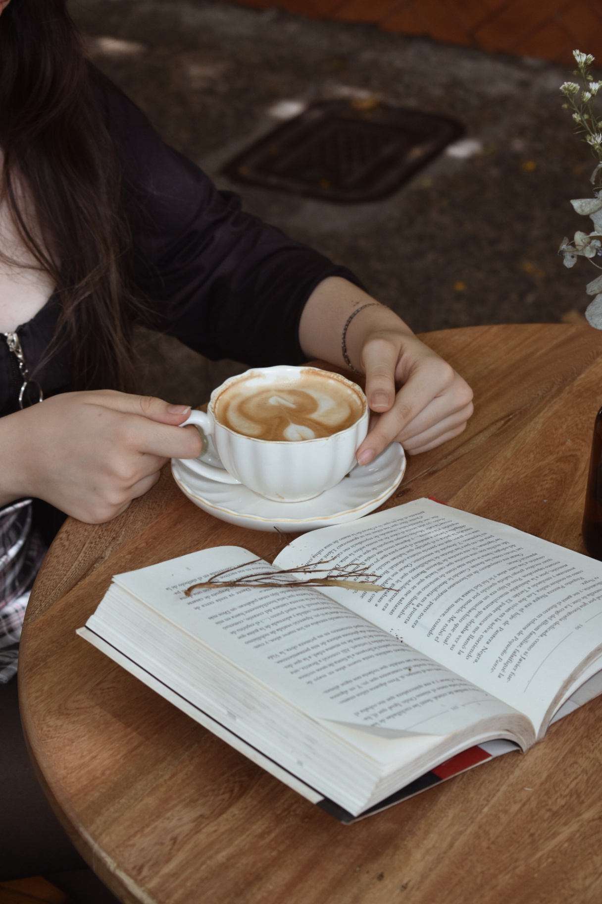 Café latte y libro sobre mesa de madera en Amelier